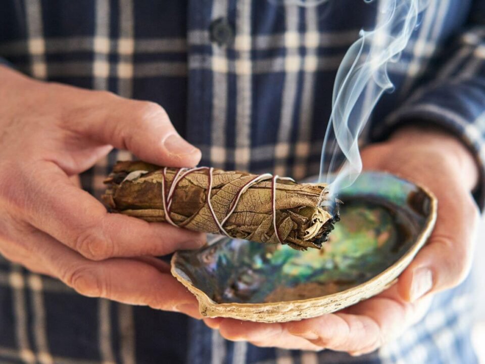 Ritual de purificação energética com incenso e cristais numa casa